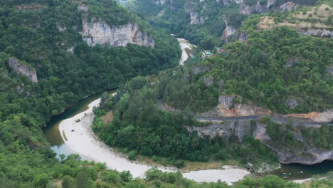 Río-Tarn-Con-Un-Camino-Sinuoso-En-Un-Cañón-Bosque-De-Pinos-Francia-Aérea